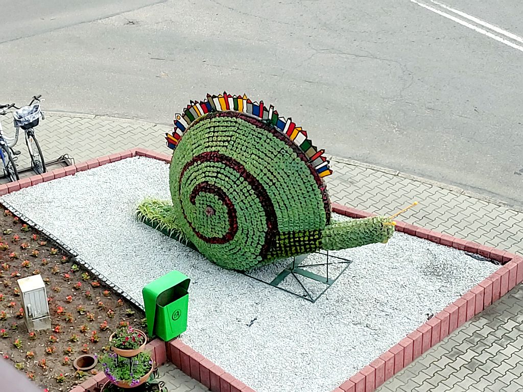 fotografia kwietnika w kształcie dużego ślimaka ustawionego przed siedzibą Urzędu Miejskiego w Kaletach